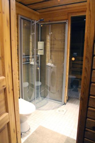 a bathroom with a glass shower and a toilet at Lapland Cabin Vonkamies in Luosto