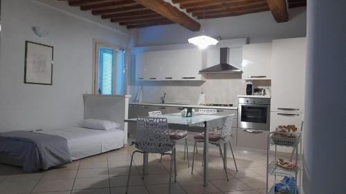 a kitchen with a bed and a table and chairs at Appartamento Il Pozzo in Capannori