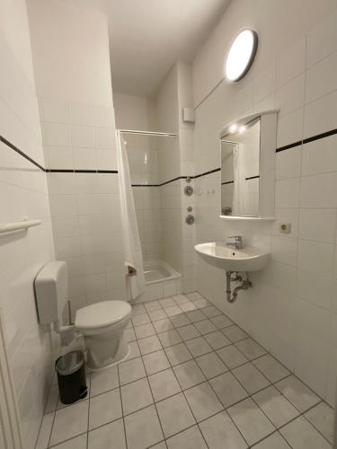a white bathroom with a toilet and a sink at Fewo Berta in Schwerin