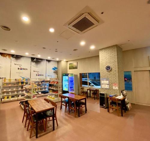 a restaurant with tables and chairs in a room at Chungmuro Merlin Hotel in Seoul