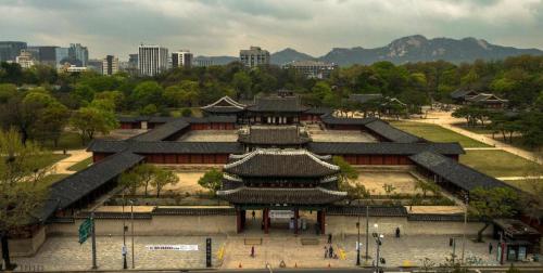 a large building in a park with a city at Chungmuro Merlin Hotel in Seoul
