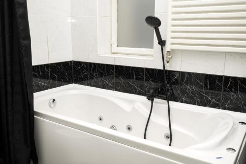 a bathroom with a bath tub with a blow dryer at Apartman BERKA in Zagreb