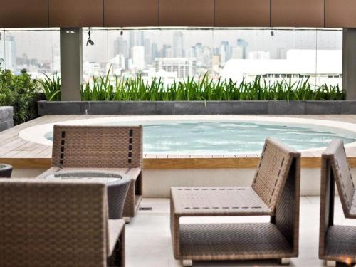 a table and chairs and a pool on top of a building at F1 Hotel Manila in Poblacion