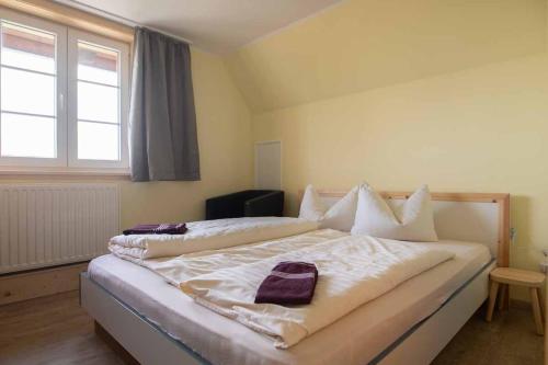 a bedroom with a large bed with white sheets and a window at Hochwaldbaude in Hain