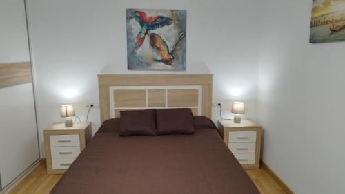 Apartamento Fuente del Genil. في Fuente Vaqueros: غرفة نوم بسرير كبير مع مواقف ليلتين