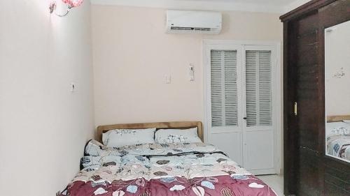 a bedroom with a bed in a white room at Family Apartment - next to Abdeen Palace and Museum in Cairo