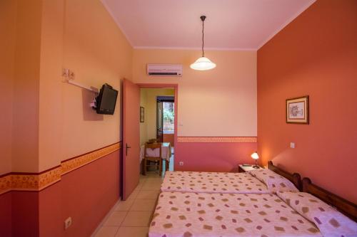 a bedroom with two beds and a tv in it at Aeriko Benovias Rooms & Apartments in Karfas