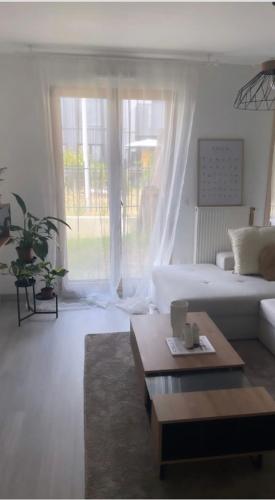 a living room with a white couch and a coffee table at Appartement cosy et bien équipé in Nanterre