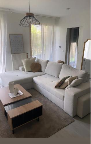 un salon avec un canapé blanc et une table basse dans l'établissement Appartement cosy et bien équipé, à Nanterre