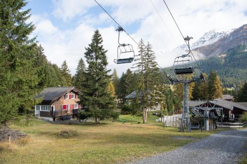 a gondola lift over a village with a house at Ferienhaus Tgantieni Ski-in Ski-out-Lenzerheide in Lenzerheide