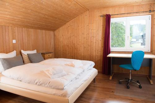 een slaapkamer met een bed, een bureau en een stoel bij Ferienhaus Tgantieni Ski-in Ski-out-Lenzerheide in Lenzerheide