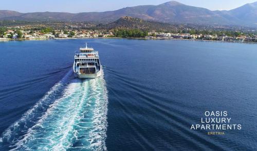 um barco viajando em um grande corpo de água em Oasis Luxury Apartments em Erétria