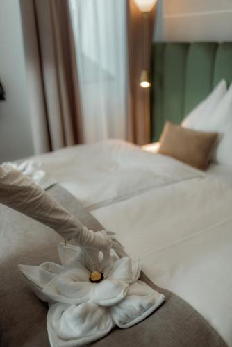 a person putting a white flower on a bed at NED Hotel in Graz