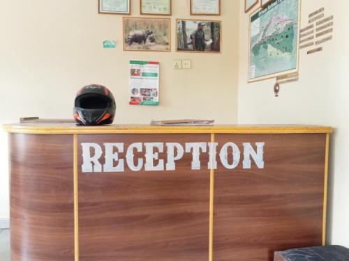 a reception desk with a helmet on top of it at Hotel Holidays Inn - Bagpacker's Home in Sauraha