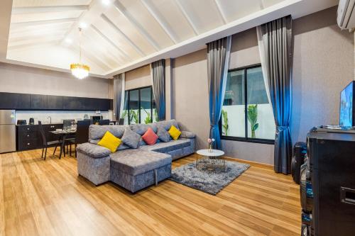 uma sala de estar com um sofá e uma mesa em PP POOL VILLA @ CHA-AM (ทรัพย์เพิ่มพูนพูลวิลล่า) em Ban Hup Kaphong