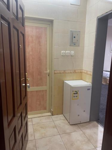 a bathroom with a small refrigerator and a door at ASFAR in Mecca