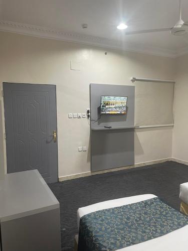 a room with a bed and a tv and a door at ASFAR in Mecca