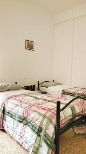 2 camas en un dormitorio con una foto en la pared en APPARTAMENTO LA SPIAGGETTA, en Foligno