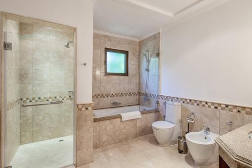 a bathroom with a toilet and a shower and a sink at Maison Privee - Prvt Pool & Beach Access in Luxury Palm Jumeirah 6BR Villa in Dubai