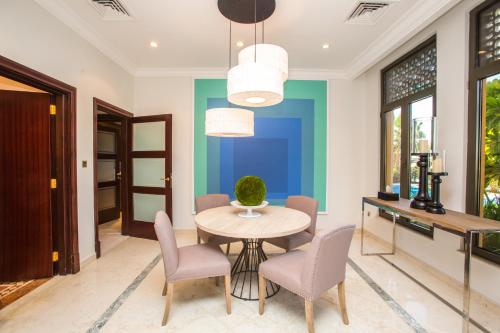 a dining room with a table and chairs at Maison Privee - Prvt Pool & Beach Access in Luxury Palm Jumeirah 6BR Villa in Dubai