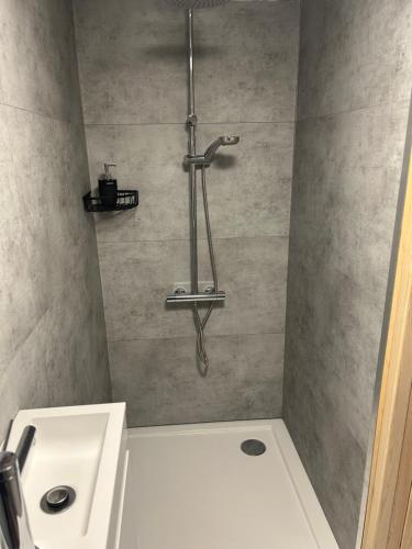 a bathroom with a shower with a white sink at Cosy@Beauty in Petit-Rechain