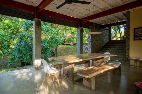 a wooden table and bench on a patio at The River House Dambulla by The Serendipity Collection in Dambulla