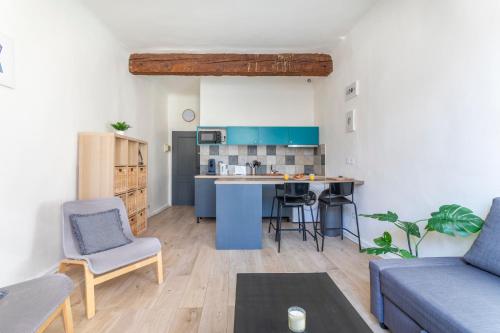 un salon avec un canapé et une cuisine dans l'établissement Studio place cardeurs, à Aix-en-Provence