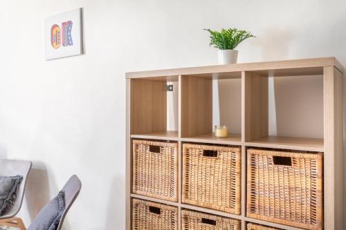 une étagère avec des paniers et une plante en haut dans l'établissement Studio place cardeurs, à Aix-en-Provence