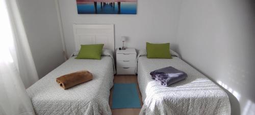 Duas camas num quarto com almofadas verdes em Habitación doble Cejilla H1 em Jerez de la Frontera