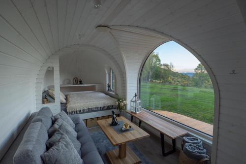 Habitación con sofá, cama y ventana en Glamping Skrytín 