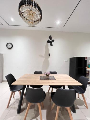 a dining room with a wooden table and chairs at Klia SomeHouse Homestay in Sepang