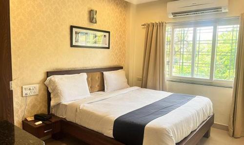 a bedroom with a large bed with a window at FabHotel Prime Golden Feather in Udaipur