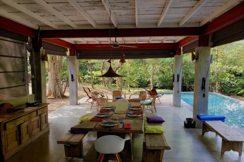 a patio with a table and chairs and a pool at The River House Dambulla by The Serendipity Collection in Dambulla