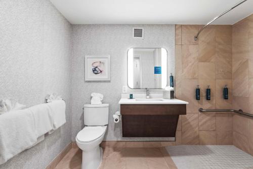 y baño con aseo, lavabo y espejo. en DoubleTree by Hilton Columbus, en Columbus