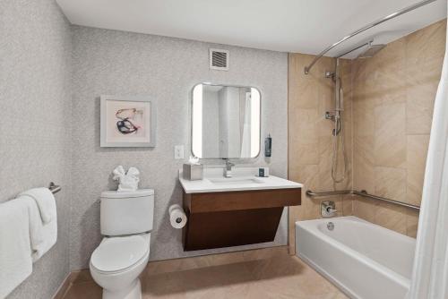 a bathroom with a toilet and a sink and a tub at DoubleTree by Hilton Columbus in Columbus