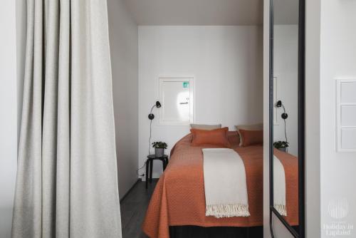 - une chambre avec un lit et une couverture orange dans l'établissement Holiday in Lapland - Ylläs Polar Charm B, à Ylläs