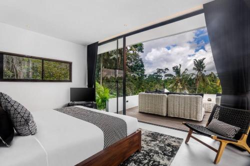 - une chambre avec un lit blanc et un balcon dans l'établissement The R Villa Cereme - nature, quite, luxurious, à Tegalalang
