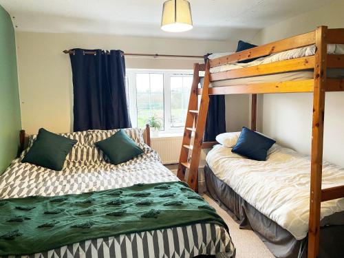 1 dormitorio con 2 literas y ventana en Alder Cottage, en Tiverton