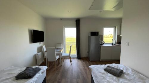 a room with two beds and a kitchen with a table at Apartment Golden Prague 78 in Vestec