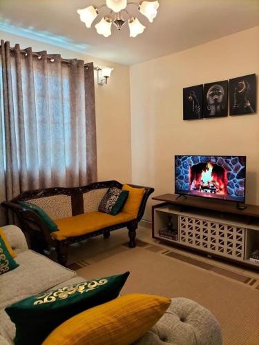 a living room with a couch and a tv at Jantabase Homes kisumu in Kisumu