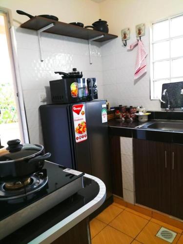 a kitchen with a black refrigerator and a sink at Jantabase Homes kisumu in Kisumu