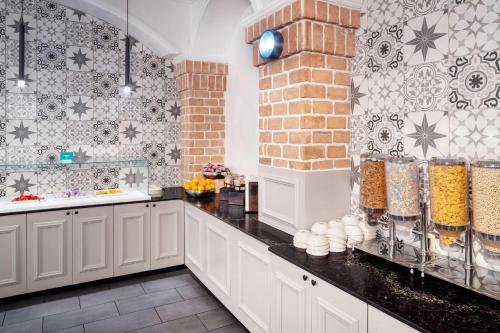 uma cozinha com armários brancos e bancadas pretas em Embassy Suites by Hilton Orlando North em Orlando