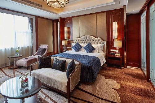 um quarto com uma cama king-size e um sofá em Wyndham Jingzhou em Jingzhou