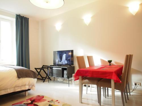 a bedroom with a dining room table with a red table cloth at Top Apartments Helsinki - Alppila in Helsinki