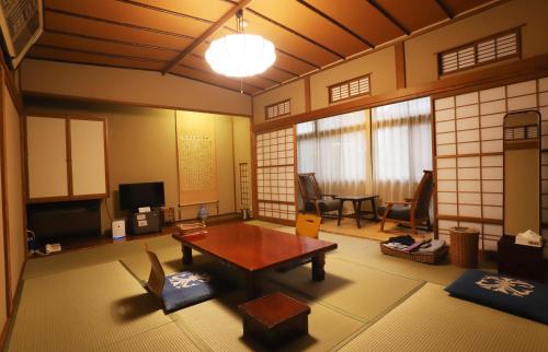 a living room with a table and a tv at 野沢温泉　奈良屋旅館 in Nozawa Onsen