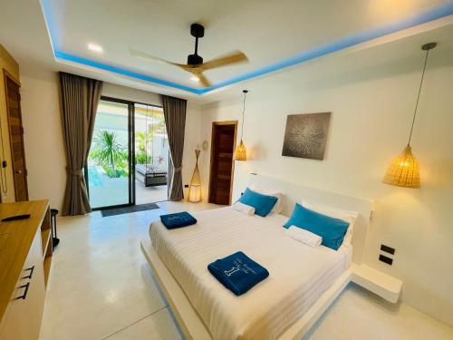 a bedroom with a large bed with blue pillows at Yuka residence in Koh Samui