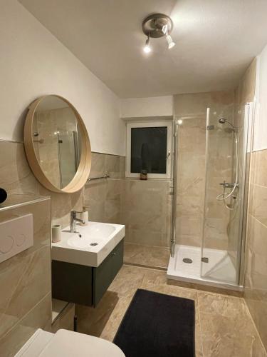 a bathroom with a shower and a sink and a mirror at Paradiesisch Wohnen Bad Schwalbach in Bad Schwalbach