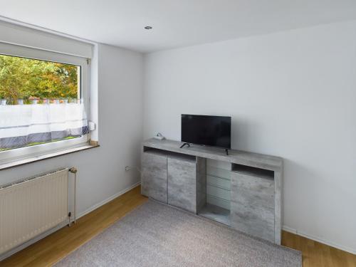 a living room with a television and a window at Aldorf 4 in Alsdorf