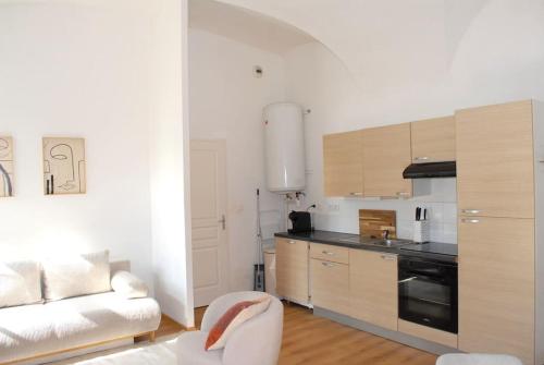 a kitchen with a couch and a table in a room at T2 a Couvent Des Cordeliers in Autun