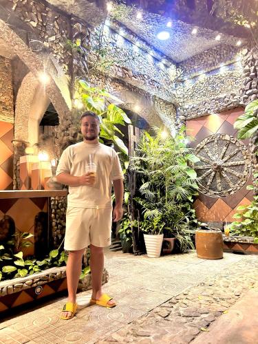 a man standing in a room with a glass of wine at Sầm Sơn Boutique Hotel Phan Thiết in Phan Thiet